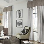 A living room in light neutral featuring drapery, valances and pillows from Carole Fabrics.