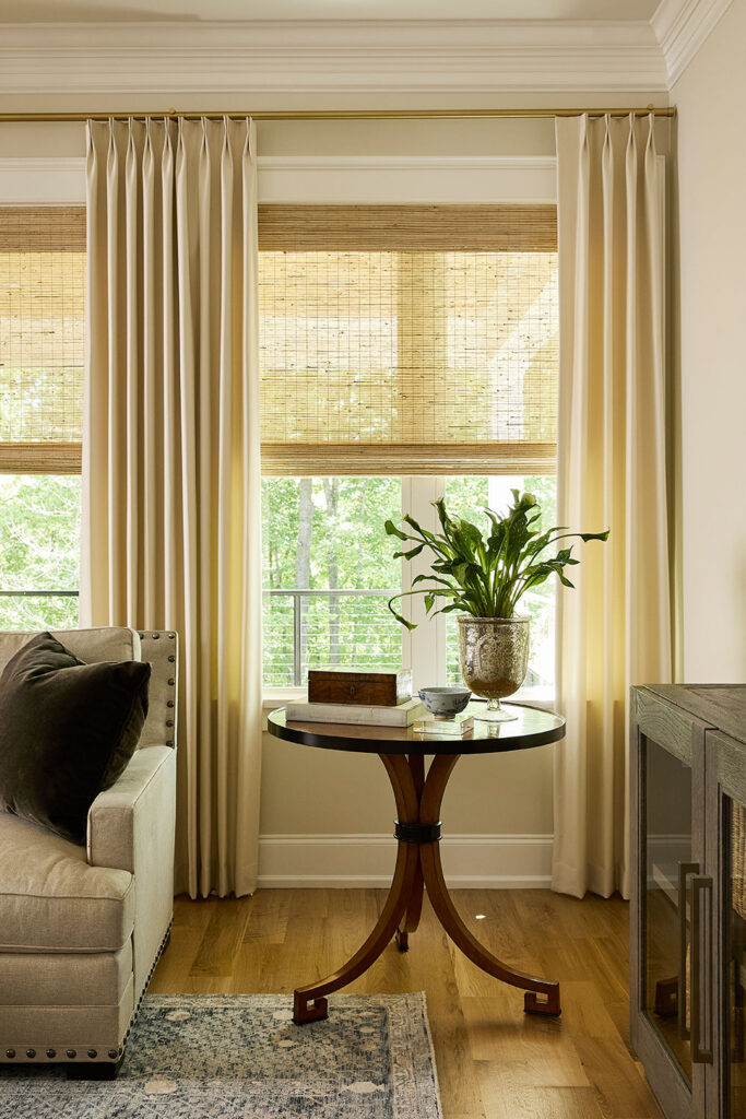 Monarch Pleat Drapery in a warm neutral color on a wall of windows in a family room.