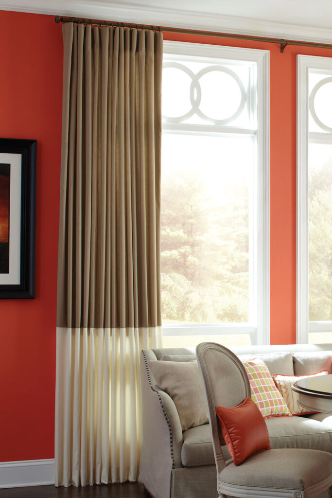 Plain Top Drapery with Stria in warm neutrals on windows in a sunny orange dining room.