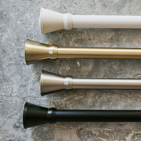 PowerView Motorized Drapery Hardware flute finials with rods in all four finishes on a grey marble background.